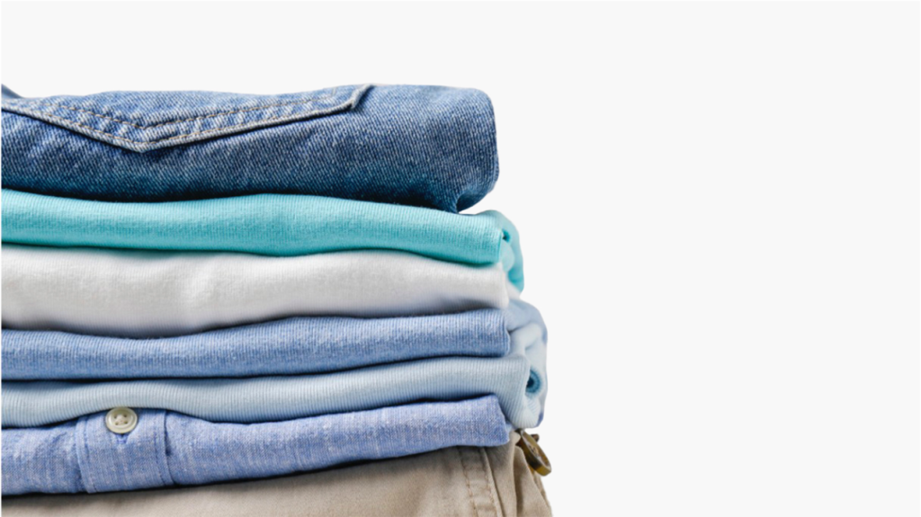 Laundry stack of clothes in blue tones after a wash dry fold laundry service.